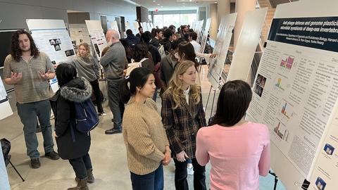 Group of students and faculty looking at scientific posters