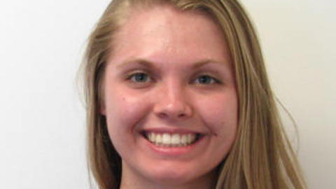 Bridget Bickner with long blonde hair and blue sleeveless top, in front of white background