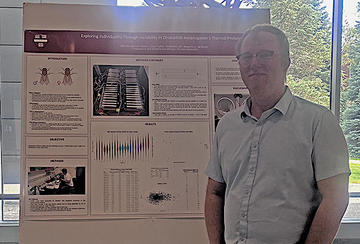 Man standing in front of a science poster