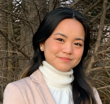 Woman outdoors wearing a pink blazer and white turtleneck