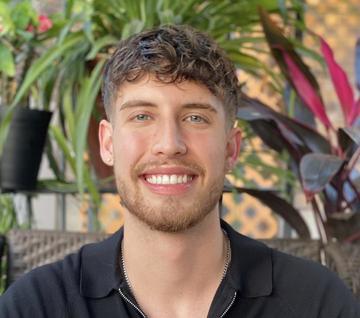 Man with a beard in front of plants