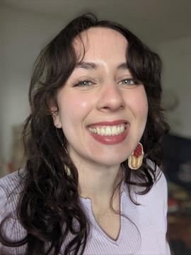 Woman with long dark hair wearing a pink top