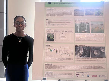 Woman standing in front of a science poster