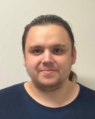 Steven Ascoet with long brown hair pulled back, wearing a black shirt