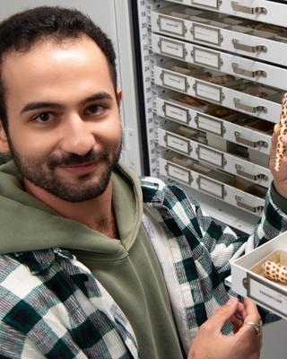 Portrait of Shayan Salehian in the MCZ collections holding a shell