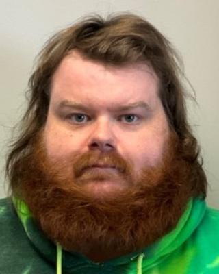 Portrait of postdoc Cade Kane wearing a green hoodie
