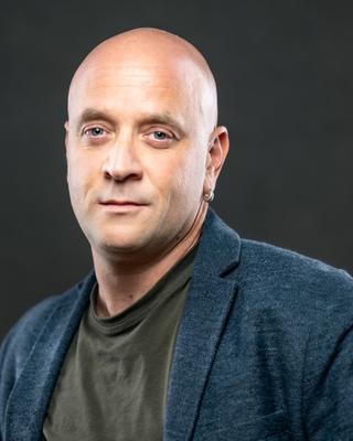 Portrait of bald man wearing a blue sports coat