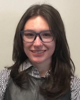Portrait of McKenna Smith with long dark hair wearing glasses