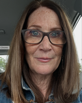 Woman with long dark hair and glasses