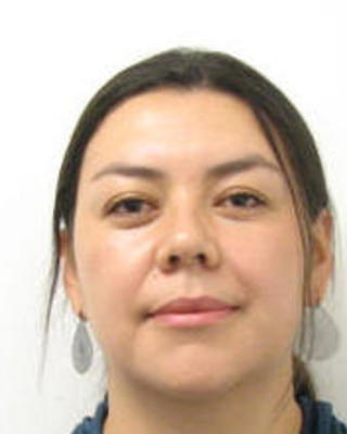 Diana Bolanos Rodriguez with long dark hair pulled back, blue collar, white background