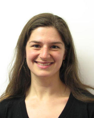 Elizabeth Wolkovich with long brown hair and a dark top, in front of a white background