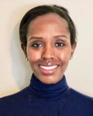 Feven Girmay smiling, with dark hair wearing a blue turtleneck