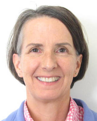 Karen Manningwith medium grey hair, pink checked shirt, lilac cardigan