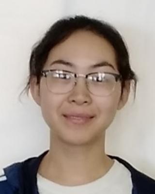 Liling Chang, long dark hair pulled back, wearing glasses, white top, and blue jacket, in front of white background