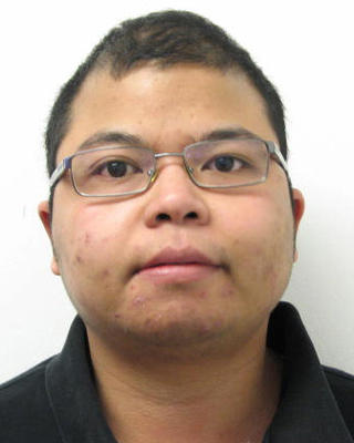 Max Thongnopphakhun with short black hair, glasses, black polo