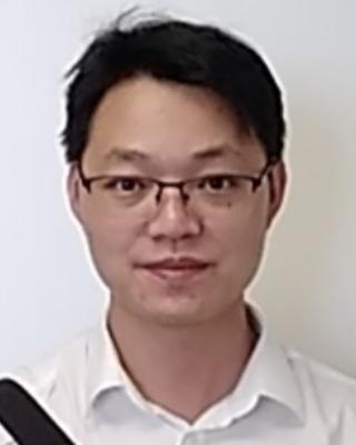 Minghai Ge with short black hair, white button down shirt, and glasses