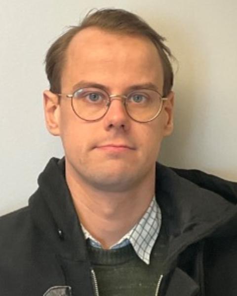 Portrait of postdoc Emil Warnberg wearing glasses and a black jacket