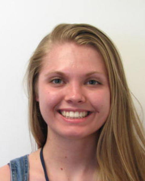 Bridget Bickner with long blonde hair and blue sleeveless top, in front of white background