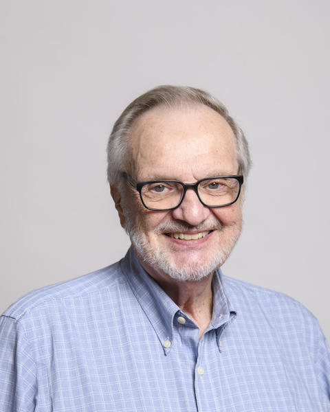Dan Hartl with gray hair and a beard wearing glasses and a blue shirt