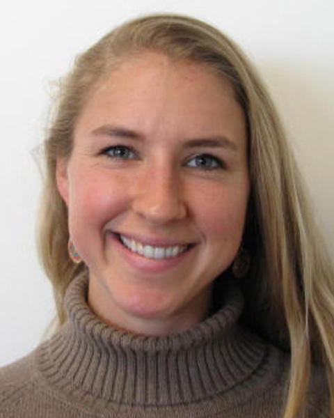 Kiah Hardcastle with long blonde hair, taupe turtleneck sweater, white background
