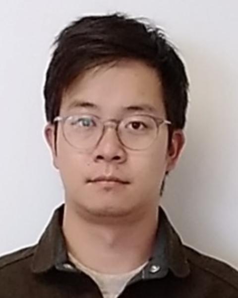 Yan Gong with short dark hair, wireframe glasses, and dark, collared shirt