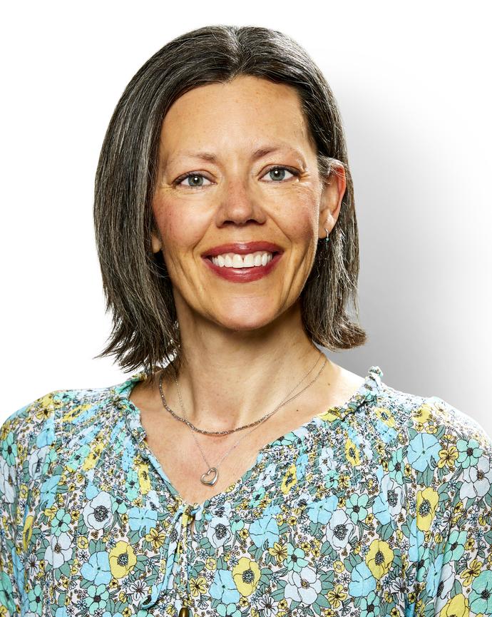Jesselynn Opie with medium brown hair in flowered blouse, white background