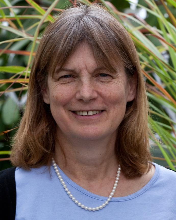Professor Noel Michele Holbrook standing in a field wearing a purple top