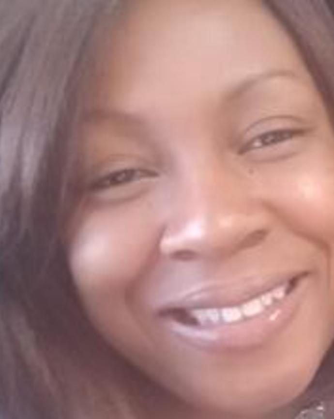 Kathy Jean-Louis smiling, with long dark brown hair