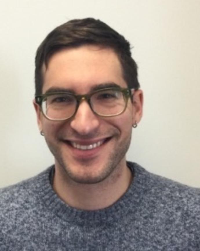 Peter Flynn with short brown hair, dark glasses, blue and white sweater
