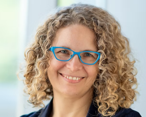 Woman with glasses in a blue blazer